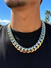 Close-up of a gold Cuban link chain worn outdoors - Showtime Gems