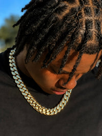 Gold Cuban link chain worn with a black tee outdoors - Showtime Gems