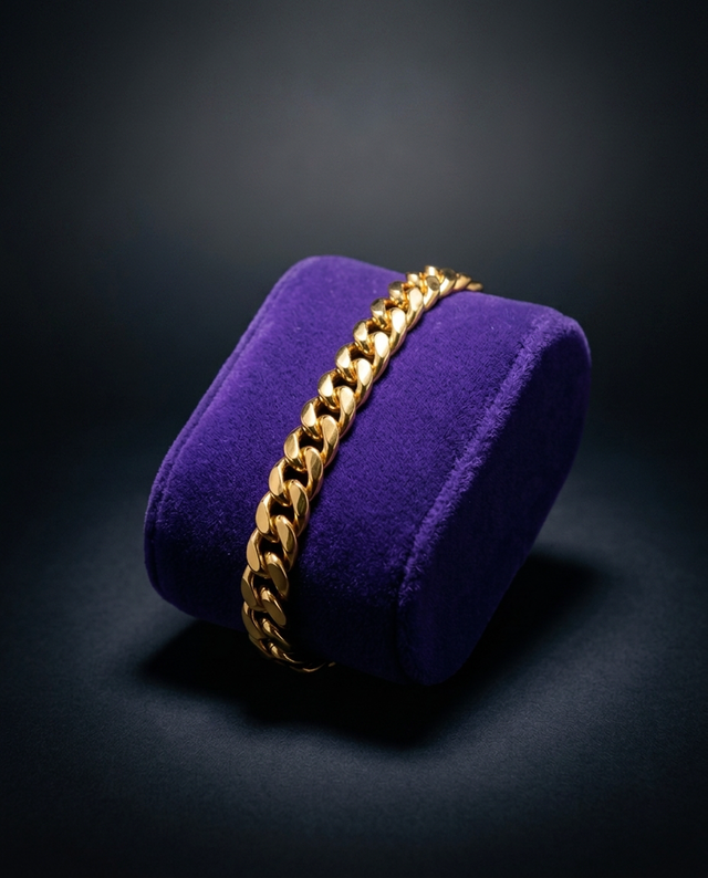 Gold Miami Cuban link bracelet on royal purple velvet, dark studio — Showtime Gems