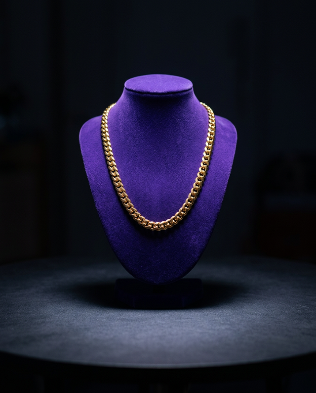 Gold Miami Cuban link chain on royal purple velvet bust, dark studio — Showtime Gems