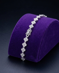 Four-leaf clover moissanite bracelet on royal purple velvet ramp — Showtime Gems