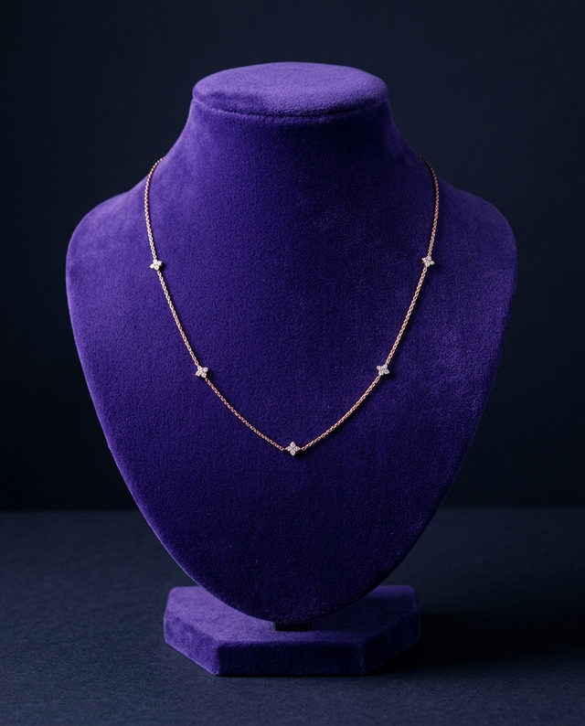 Rose gold clover-station moissanite necklace on royal purple velvet bust — Showtime Gems
