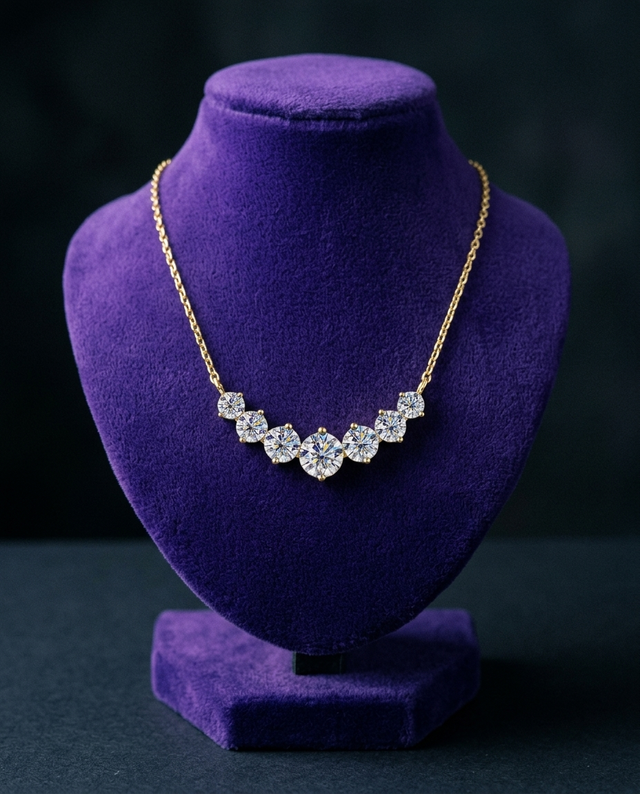 7-stone graduated moissanite necklace on royal purple velvet bust — Showtime Gems