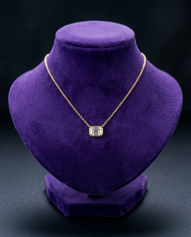 Emerald-cut moissanite bezel pendant on royal purple velvet bust — Showtime Gems